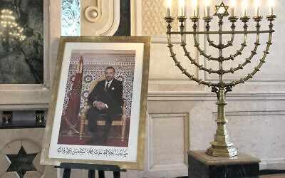 Une photo du roi marocain Mohammed VI à côté d'une ménorah à la synagogue Bet El de Casablanca, le 12 août 2021. (Crédit : Lazar Berman/Times of Israel)