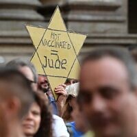 Illustration : Un manifestant tient une étoile jaune sur laquelle on peut lire "Pas de vaccin = Juif" alors que des manifestants prennent part à une manifestation à Milan, le 24 juillet 2021, contre l'introduction d'un "laissez-passer vert" obligatoire pour les restaurants intérieurs et les lieux de divertissement, dans le but de limiter la propagation du coronavirus. (Crédit : MIGUEL MEDINA / AFP)