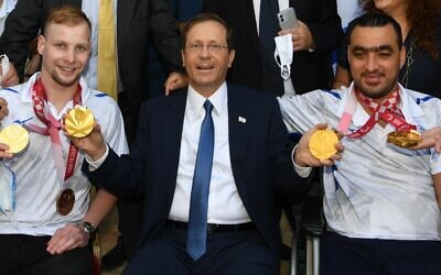 Le président Isaac Herzog pose pour une photo avec les médaillés paralympiques Mark Malyar (à gauche) et Iyad Shalabi (à droite) à la résidence du président à Jérusalem, le 14 septembre 2021. (Amos Ben Gershom/GPO)