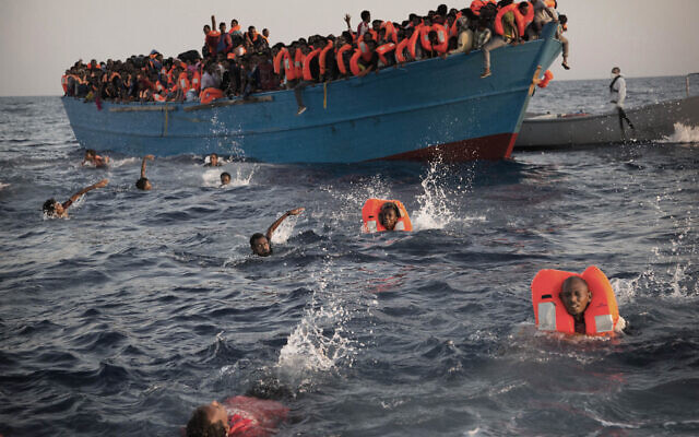 Illustration. Sur cette photo d'archive du 29 août 2016, des migrants, la plupart originaires d'Érythrée, sautent dans l'eau depuis un bateau en bois bondé alors qu'ils sont aidés par des membres d'une organisation non gouvernementale lors d'une opération de sauvetage en mer Méditerranée, à environ 13 miles (20 kilomètres) au nord de Sabratha, en Libye. (AP/Emilio Morenatti)