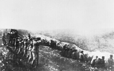 Cette photo, prise sur le corps d'un officier allemand tué en Russie, montre un peloton d'exécution allemand tirant dans le dos des civils assis à côté de leur propre charnier, à Babi Yar, Kiev, 1942. (Crédit : Photo AP)