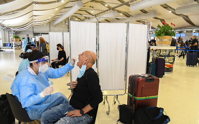Des laborantins testent des passagers pour le COVID-19 à l'aéroport international Ben Gurion près de Tel Aviv le 8 mars 2021. (Crédit : Flash90)