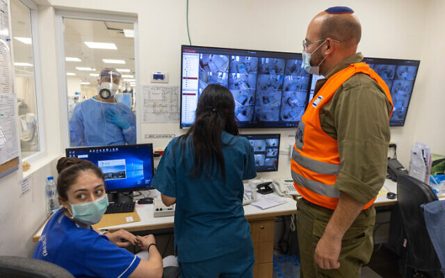 Le personnel de l'hôpital Shaare Zedek et un soldat de Tsahal réunis autour d'écrans d'ordinateur le 14 octobre 2021. (Crédit : Olivier Fitoussi/Flash90)