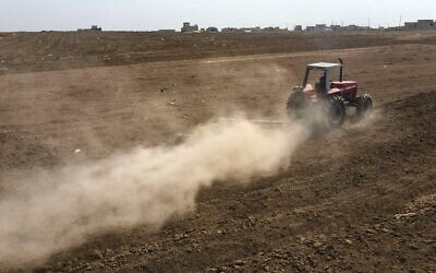 Un tracteur laboure une parcelle de terre agricole, à la périphérie de la ville de Tel Keppe (Tel Kaif) au nord de la ville de Mossoul, dans la province irakienne de Ninive (nord), le 26 octobre 2021. (Crédit :  Zaid AL-OBEIDI / AFP)