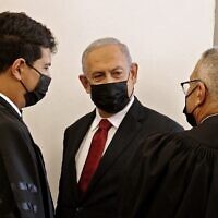 L'ex-Premier ministre Benjamin Netanyahu, au centre, arrive pour une audience dans son procès pour corruption au tribunal de Jérusalem, le 16 novembre 2021. (Crédit :   JACK GUEZ / AFP)