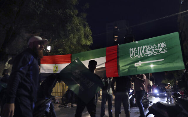 Des Libanais tiennent une bannière affichant les drapeaux de l'Arabie saoudite, des Émirats arabes unis et de l'Égypte, lors d'une manifestation de soutien au royaume contre les commentaires d'un ministre libanais sur la guerre au Yémen, devant l'ambassade d'Arabie saoudite à Beyrouth, au Liban, le 30 octobre 2021. (Crédit : AP Photo/ Bilal Hussein)
