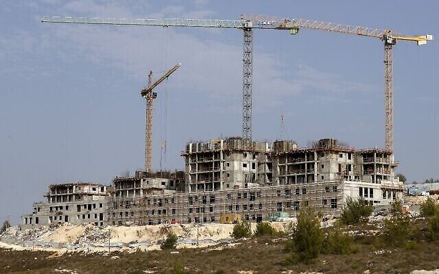 Travaux de construction dans l'implantation israélienne de Givat Zeev, près de la ville palestinienne de Ramallah, en Cisjordanie, le 28 octobre 2021 (Crédit : Ahmad Gharabli/AFP).