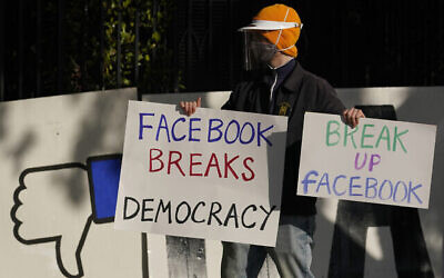 Un manifestant rejoint d'autres personnes devant le domicile du PDG de Facebook, Mark Zuckerberg, à San Francisco, pour protester contre ce qu'ils disent être la diffusion de désinformation par Facebook, le 21 novembre 2020. (Crédit : AP Photo/Jeff Chiu, File)