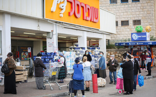Illustration : Des clients devant un supermarché Shufersal à Safed, le 6 avril 2020. (Crédit : David Cohen/Flash90)