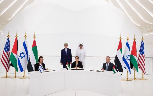 De gauche à droite : la ministre de l'Énergie et des Ressources en eau Karine Elharrar, la ministre des Émirats arabes unis Mariam Almheiri et le ministre jordanien de l'Eau et de l'Irrigation Mohammed Al-Najjar signent un accord sur l'eau lors d'un événement à l'Expo de Dubaï le 22 novembre 2021. En tant qu'envoyé américain pour le climat John Kerry et la Couronne des Émirats arabes unis le prince Mohammed ben Zayed assistent à la signature. (Crédit : Ministère des Affaires étrangères des Émirats arabes unis/Twitter)