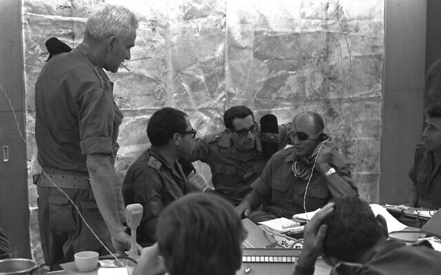 Le ministre de la Défense Moshe Dayan dans la salle de guerre au siège de l'armée israélienne à Tel Aviv, le 8 octobre 1973. A ses côtés, à droite, le général Rehavam Zeevi, le général Shmuel Gonen et le général Uri Ben-Ari. (Crédit : GPO/Arad Shlomo)