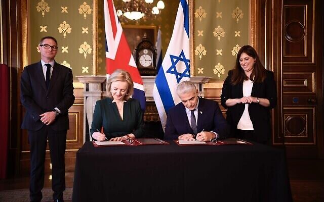 Le ministre des Affaires étrangères, Yair Lapid (R), signe un protocole d'accord avec la ministre britannique des Affaires étrangères, Liz Truss, au Foreign Office, à Londres, le 29 novembre 2021. (Crédit : Stuart Mitchell/GPO)