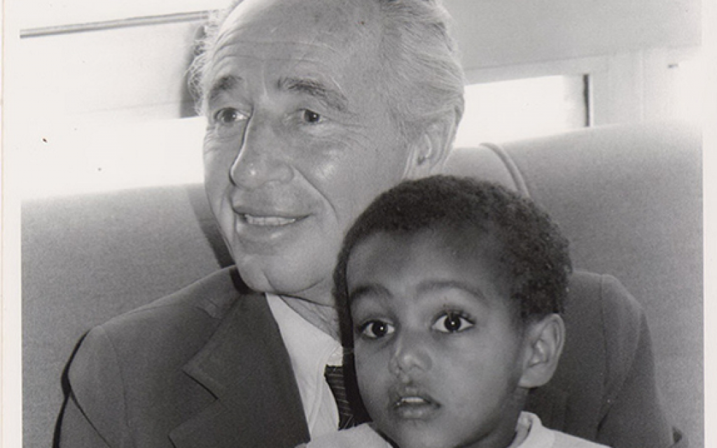 Le Premier ministre israélien de l'époque, Shimon Peres, avec un enfant amené en Israël lors de l'opération Moïse de 1984, qui a fait venir des Juifs éthiopiens en Israël (Crédit : Archives du ministère de la Défense).
