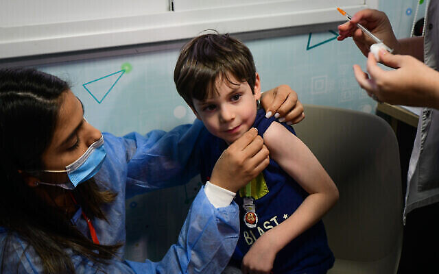 Un garçon israélien Itamar, 5 ans, reçoit une dose du vaccin Pfizer/BioNTech Covid-19 à l'Organisation des services de santé Meuhedet à Tel Aviv, le 22 novembre 2021, alors qu'Israël commence sa campagne de vaccination contre le coronavirus pour les enfants de 5 à 11 ans. (Crédit : JACK GUEZ / AFP)
