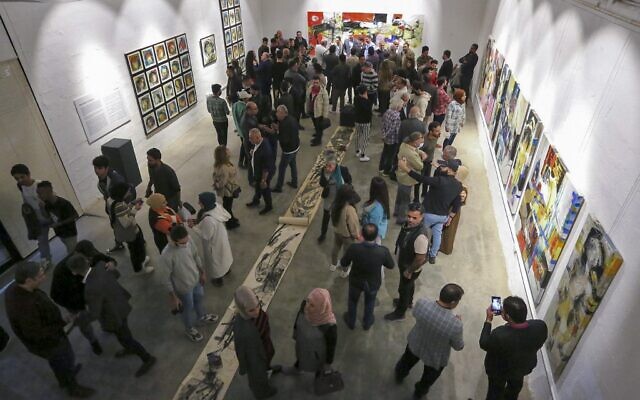 Des visiteurs assistent à l'ouverture d'une exposition de l'artiste plasticien Riyadh Ghenea dans la capitale irakienne, Bagdad, le 26 novembre 2021. (Crédit : Sabah ARAR / AFP)