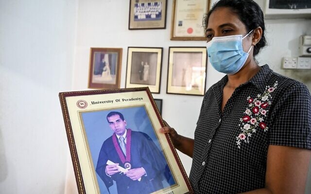 Nilushi Dissanayake, l'épouse du directeur d'usine sri-lankais qui a été battu à mort et immolé par une foule au Pakistan, tient la photo de remise des diplômes de son mari à sa résidence à Ganemulla près de Colombo, le 5 décembre 2021. (Crédit : Ishara S. KODIKARA / AFP )