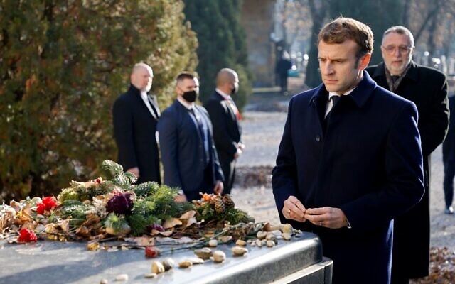 Le président français Emmanuel Macron rend hommage aux victimes de la Shoah lors de sa visite au cimetière juif de Budapest le 13 décembre 2021, au début de sa visite d'État d'une journée en Hongrie. (Crédit : Ludovic MARIN / AFP)
