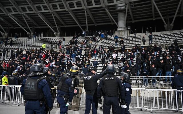 Des CRS face à des supporters lors de la mi-temps du match de 16e de finale de Coupe de France entre le Paris FC et l'Olympique Lyonnais au stade Charlety à Paris, le 17 décembre 2021. Le match a été interrompu en raison d'incidents dans les tribunes. (Crédit : BERTRAND GUAY / AFP)