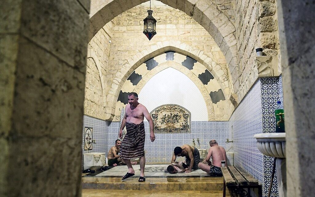 Des hommes se baignent à Hammam al-Qawas, un bain turc traditionnel, dans la ville d'Alep, au nord de la Syrie, le 16 décembre 2021. (Crédit : AFP)