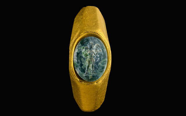 Un anneau en or avec une pierre précieuse verte sur laquelle l'image du "Bon Berger" est représentée. (Crédit :  Dafna Gazit/Autorité des antiquités israéliennes)