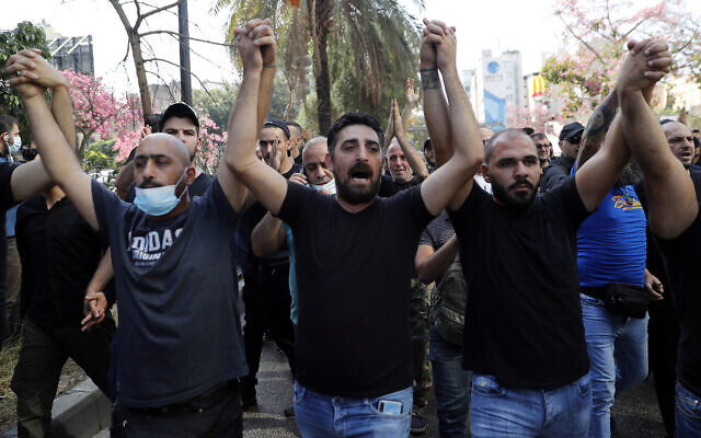Des partisans des groupes chiites Hezbollah et Amal scandent des slogans contre le juge Tarek Bitar qui enquête sur l'explosion meurtrière du port maritime de l'année dernière, lors d'une manifestation devant le palais de justice de Beyrouth, au Liban, le 14 octobre 2021. (Crédit : AP Photo/Hussein Malla)