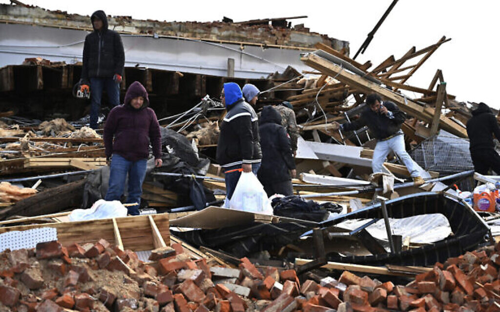 Une famille fouille dans les restes de son appartement à Mayfield, Kentucky, samedi 11 décembre 2021. Des tornades et des intempéries ont causé des dégâts catastrophiques dans plusieurs États vendredi soir, faisant plusieurs victimes dans la nuit. (AP Photo/Timothy D. Easley)