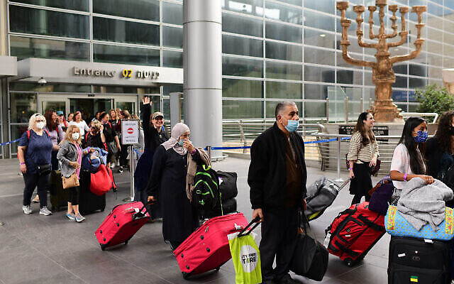 Des voyageurs sortent de l'aéroport international Ben Gurion, alors qu'Israël ouvre ses frontières et autorise les touristes à entrer dans le pays, après des mois de fermeture en raison de la pandémie de COVID-19, le 1er novembre 2021. (Tomer Neuberg/FLASH90)