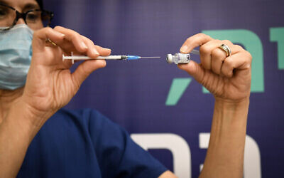 Un employé du secteur de la santé prépare un vaccin contre la COVID-19 à l'hôpital Sheba de Ramat Gan, le 28 décembre 2021. (Crédit :  Yossi Zeliger/Flash90)