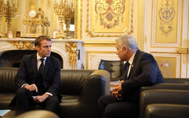 Le ministre des Affaires étrangères Yair Lapid, à droite, parle au président Emmanuel Macron, à Paris, le 30 novembre 2021. (Crédit : MFA/Quentin Crestinu)