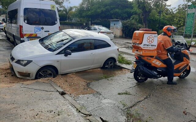 Une voiture tombée dans un gouffre à Netanya, le 21 décembre 2021. (Crédit : United Hatzalah)