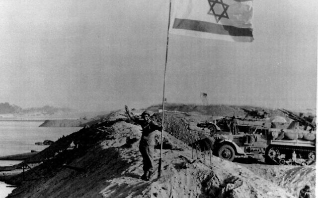 Sur cette photo d'archive du 30 octobre 1973, un énorme drapeau israélien à l'étoile de David flotte au-dessus de la rive est du canal de Suez, qui a été reconquise en octobre. Les forces égyptiennes, ont envahi, le canal au début de la guerre du Kippour. Israël s'est ensuite retiré, de la rive orientale,  afin que le canal puisse être rouvert après une trêve. Israël célèbre le 60e anniversaire de sa fondation le 14 mai 2008. (Crédit : photo AP)