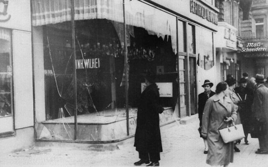 Un homme regarde les décombres d'un magasin juif à Berlin le 10 novembre 1938, au lendemain de la Nuit de cristal, une attaque nationale organisée menée par les forces paramilitaires nazies et les civils allemands pendant deux jours. (Crédit : AP)