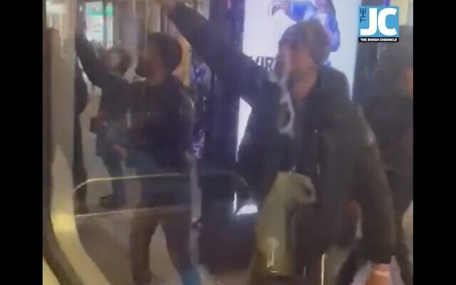 Un homme (Droite) semble faire un salut nazi, dans une vidéo montrant un groupe de personnes accostant des Juifs dans un bus Chabad alors qu'ils célébraient Hanoukka à Londres, le 28 novembre 2021. (Crédit : capture d'écran : Twitter)