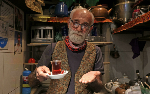 Illustration : un Iranien avec une tasse de thé. (Crédit : ATTA KENARE/AFP/Archive)