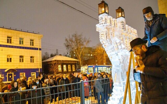 Le rabbin Levy Kaminetsky se prépare  à allumer une ménorah de Hanoukka faite de glace à l'extérieur de sa synagogue à Tomsk, en Russie, le 28 novembre 2021. (Autorisation/Levy Kaminetsky via JTA)