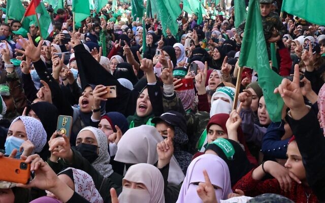 Des femmes agitent les mains lors d'un rassemblement dans le camp de réfugiés de Jabaliya, dans la bande de Gaza, à l'occasion du 34e anniversaire de la fondation du Hamas, qui dirige l'enclave côtière, le 10 décembre 2021. (Mohammed ABED / AFP)
