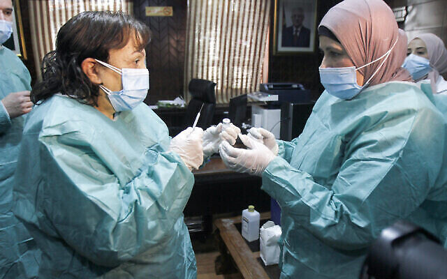 Des agents de santé palestiniens dans un hôpital de la ville de Naplouse, en Cisjordanie, où des agents de santé ont été vaccinés contre le coronavirus (COVID-19) plus tôt dans la journée, après la livraison de doses de vaccin par Israël, le 3 février 2021. (Nasser Ishtayeh/Flash90)
