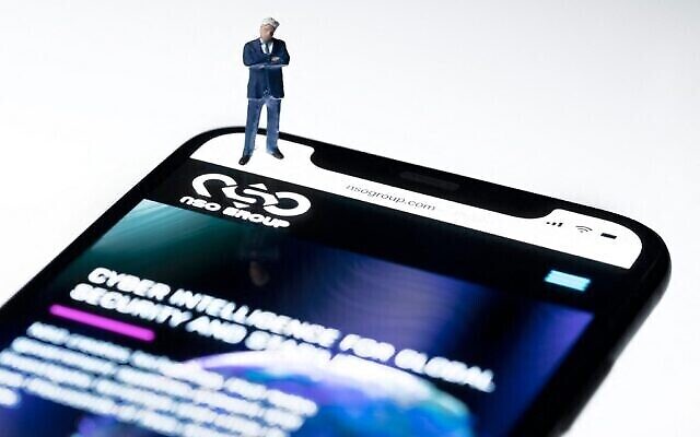 Cette illustration photographique de studio montre un smartphone avec le site web du groupe israélien NSO qui comporte le logiciel espion "Pegasus", exposé à Paris, le 21 juillet 2021. (Joel Saget/AFP)