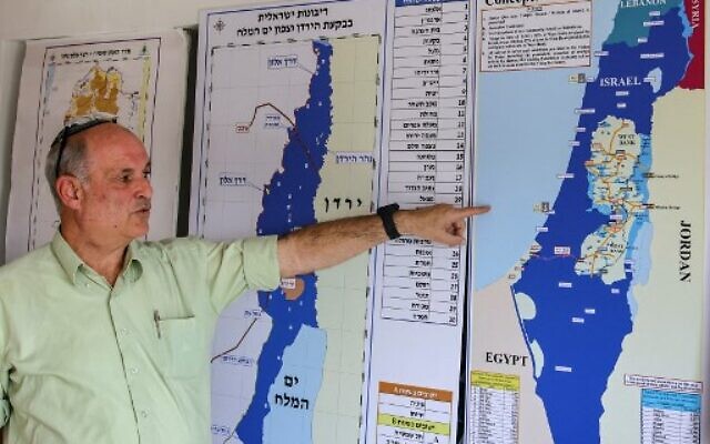 Dany Tirza, 63 ans, un ancien colonel de l'armée israélienne montre une carte alors qu'il s'adresse à l'AFP dans son bureau de l'implantation juive de Kfar Adumim en Cisjordanie, le 14 décembre 2021. Crédit :