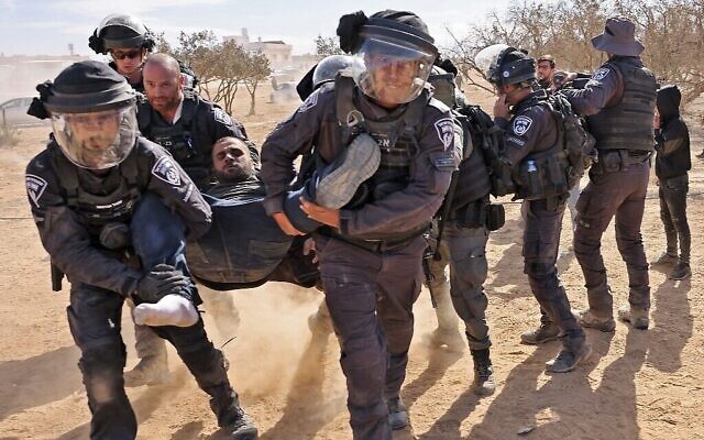 La police israélienne détient un homme alors que des Bédouins protestent dans le désert du Néguev contre un projet de plantation du Fonds national juif (JNF), le 12 janvier 2022. (Crédit : AHMAD GHARABLI / AFP)