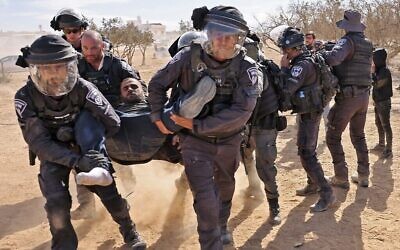 La police israélienne arrête un homme lors d'une manifestation des Bédouins contre un programme de reboisement entrepris par le KKL-JNF dans le sud du Negev, le 12 janvier 2022. (Crédit : AHMAD GHARABLI / AFP)