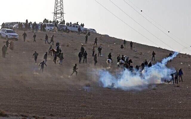 Des manifestants bédouins et des forces israéliennes s'affrontent lors d'une manifestation dans le village de Sawe al-Atrash, dans le sud d'Israël, dans le désert du Neguev, contre un projet de boisement du Fonds national juif (FNJ), le 13 janvier 2022. (Crédit : Menahem KAHANA / AFP)