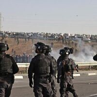 Des manifestants bédouins et des forces israéliennes s'affrontent lors d'une manifestation dans le village de Sawe al-Atrash, dans le sud d'Israël, dans le désert du Neguev, contre un projet de reboisement du Fonds national juif (FNJ), le 13 janvier 2022. (Crédit : Menahem KAHANA / AFP)