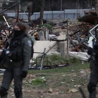 Les forces israéliennes devant les ruines d'une maison palestinienne démolie dans le quartier de Sheikh Jarrah à Jérusalem, le 19 janvier 2022. (Crédit : Ahmad Gharabli/AFP)