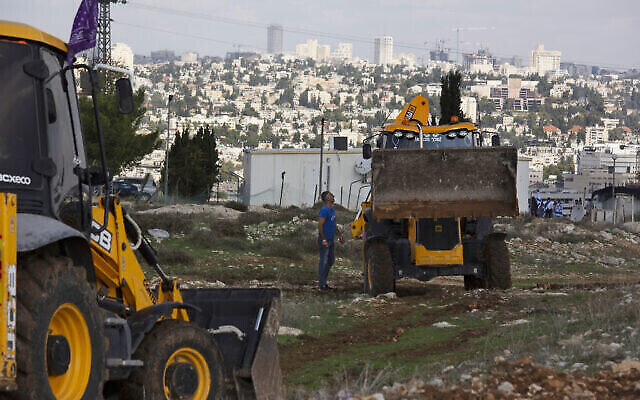 Des ouvriers font une pause avant la visite de responsables de l'Union européenne sur le chantier de construction du quartier de Givat Hamatos, à Jérusalem-Est, le 16 novembre 2020. (Crédit : AP Photo/Maya Alleruzzo)