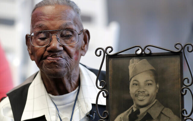 Lawrence Brooks, ancien combattant de la Seconde Guerre mondiale, tient une photo de lui prise en 1943, alors qu'il célèbre son 110e anniversaire au National World War II Museum à la Nouvelle-Orléans, le 12 septembre 2019. (Crédit : AP Photo/Gerald Herbert, File)