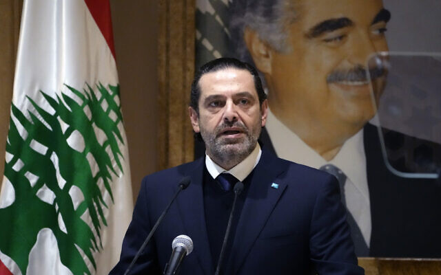 L'ancien Premier ministre libanais Saad Hariri s'exprime lors d'une conférence de presse devant une photo de son défunt père et ancien Premier ministre du Liban Rafic Hariri, dans sa maison du centre-ville de Beyrouth, au Liban, le 24 janvier 2022. (Crédit : Hussein Malla/AP)