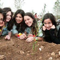 De jeunes filles plantent des arbres lors d'un événement de Tou Bishvat organisé par le Keren Kayemet LeIsrael dans la forêt de Ben Shemen, le 6 février 2012. (Omer Miron/Flash90)
