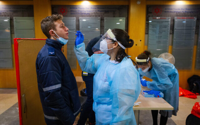 Une infirmière du Magen David Adom effectue un test antigénique sur l'un de ses collègues dans un centre de dépistage de Jérusalem, le 9 janvier 2022. (Crédit :  Olivier Fitoussi/Flash90)