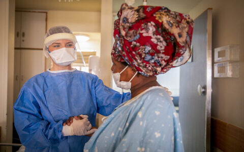 Un soignant et une patiente dans l'unité COVID de l'hôpital Kaplan à Rehovot, le 18 janvier 2022. (Crédit : Yossi Aloni/Flash90)